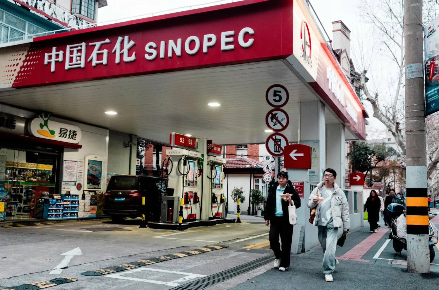 People walk past SINOPEC petrol station, in Shanghai, China, 19 March 2026.  EPA/ALEX PLAVEVSKI