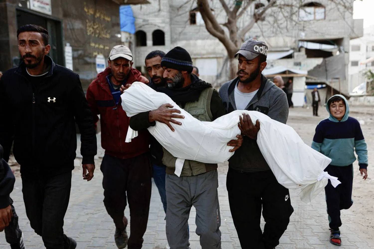 فلسطيني يحمل جثمان أحد أقربائه قتل في غارة جوية إسرائيلية بمدينة غزة (أ.ف.ب)