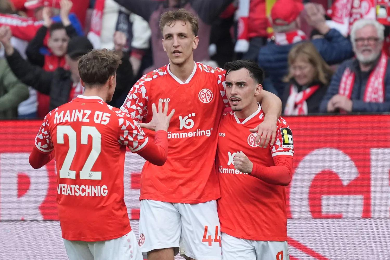 Mainz' scorer Paul Nebel, right, and his teammates Nelson Weiper, center, and Nikolas Veratschnig, left, celebrate their side's second goal during the German Bundesliga soccer match between 1.FSV Mainz 05 and Eintracht Frankfurt in Mainz, Germany, Sunday, March 22, 2026. (Marc Schueler/dpa via AP)