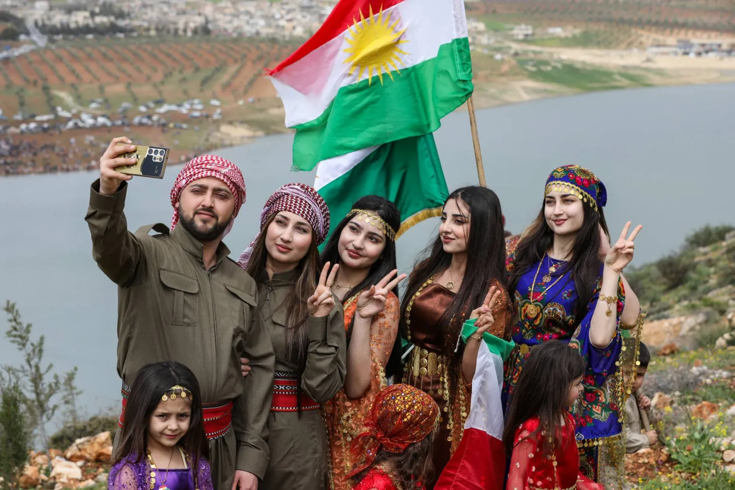 أكراد سوريون يلتقطون صوراً تذكارية احتفالاً بعيد النوروز في عفرين بريف حلب شمال سوريا السبت (رويترز)