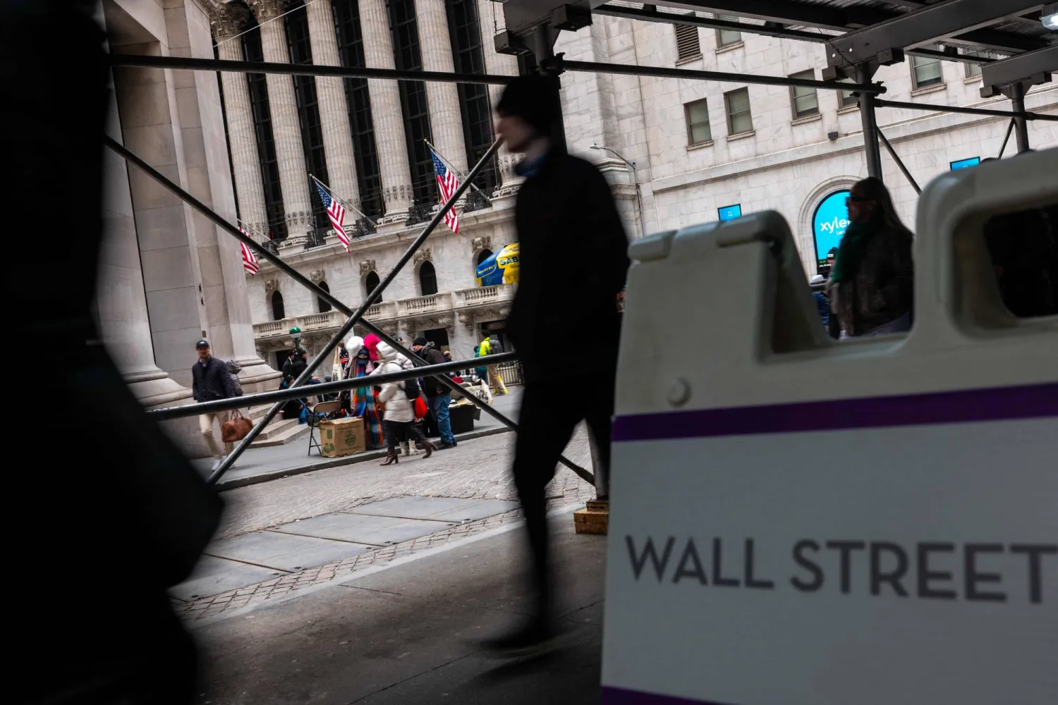 يسير أشخاص في الحي المالي حيث مقر بورصة نيويورك في مانهاتن (أ.ف.ب)