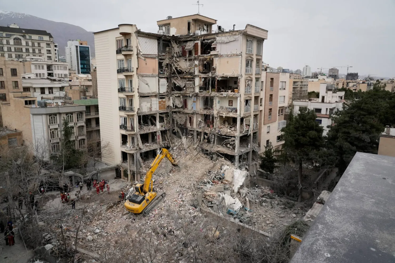 Iranian Red Crescent emergency workers use a bulldozer to clear rubble from a residential building that was hit in an earlier US-Israeli strike in Tehran, Iran, Monday, March 23, 2026. (AP Photo/Vahid Salemi)