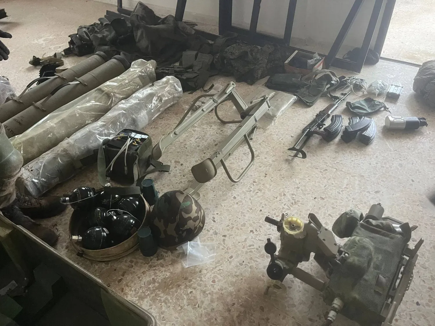 İsrail ordusu sözcüsü Avichay Adraee'nin dün akşam paylaştığı ve Rıdvan Gücü üyelerinin teslim olmasının ardından ele geçirilen silahlara ait olduğunu belirttiği fotoğraf