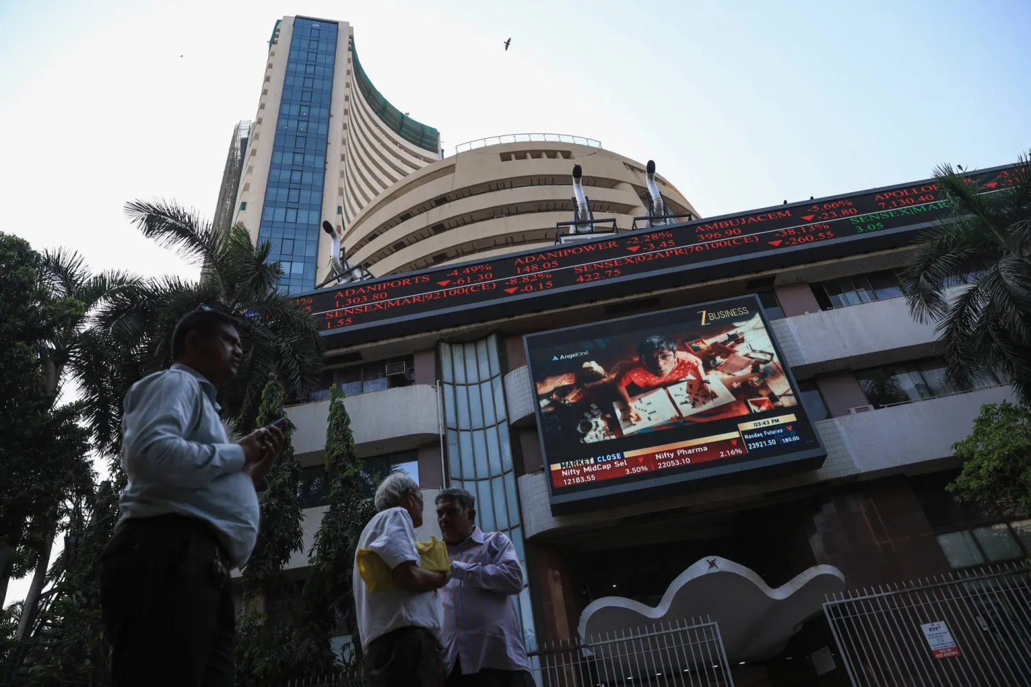 يمر الناس بجانب مبنى بورصة بومباي في الهند (إ.ب.أ)