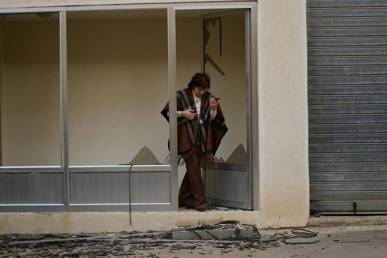 لبنانية تتفقد الأضرار الناتجة عن سقوط شظايا صاروخ إيراني تم اعتراضه فوق منطقة جونيه في جبل لبنان (أ.ب)