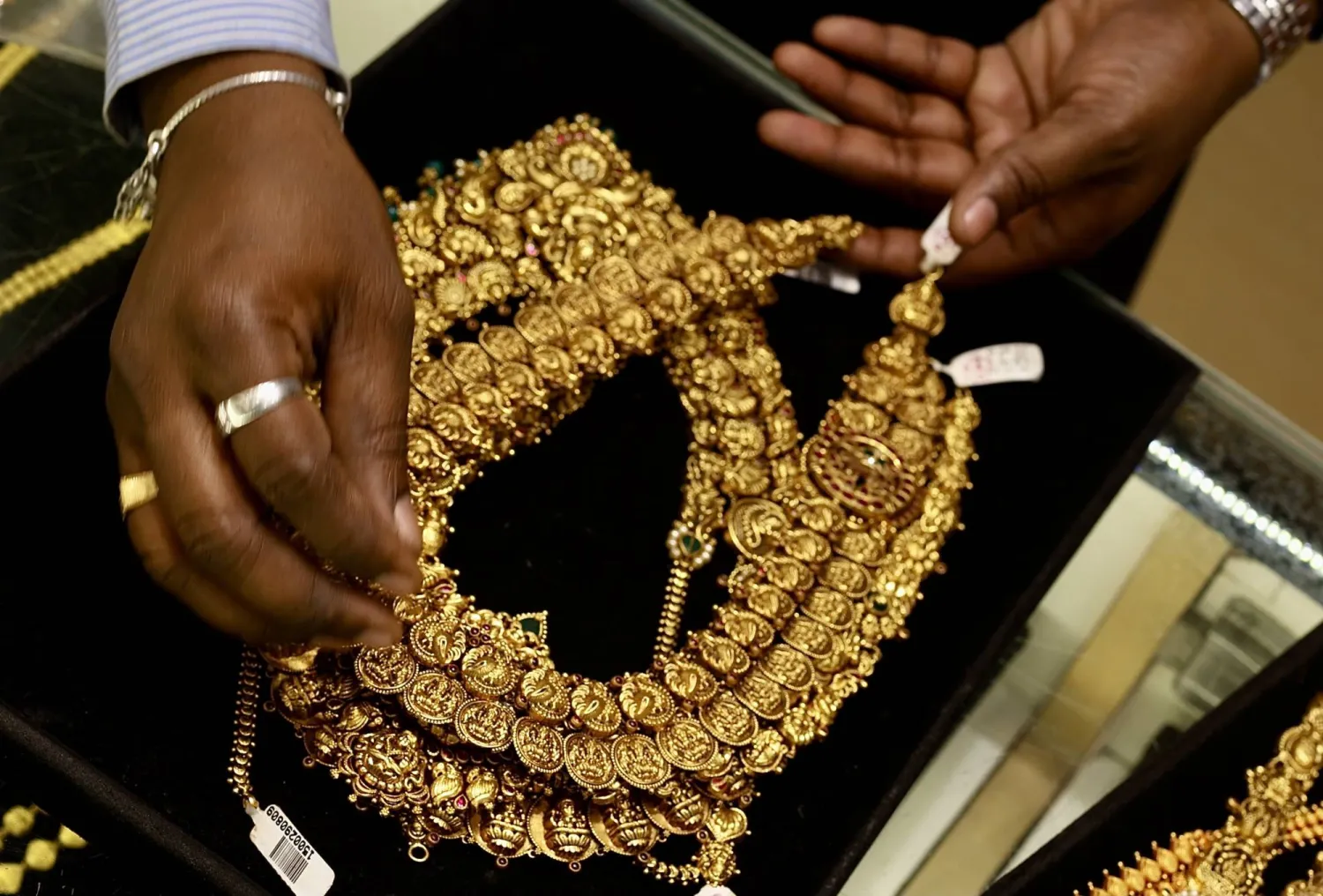 امرأة هندية تعرض قطعة مجوهرات ذهبية في متجر مجوهرات في بنغالور (إ.ب.أ)