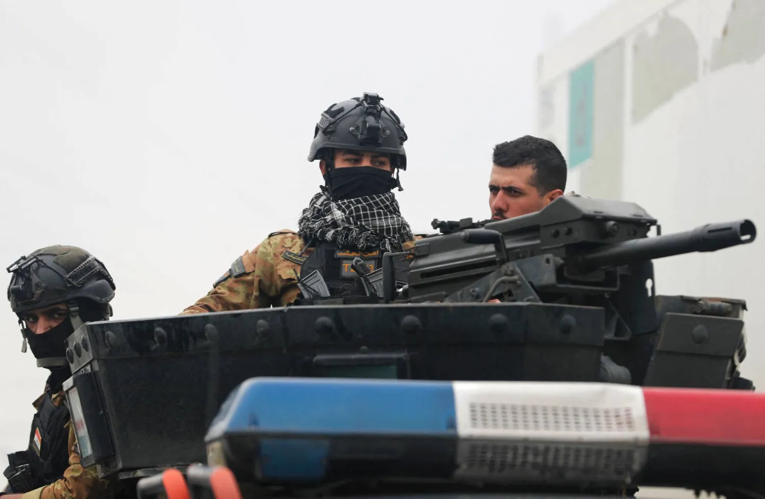 Members of Iraq’s PMF guard the streets during the funeral for members of the PMF in Baghdad on March 24, 2026. (AFP)