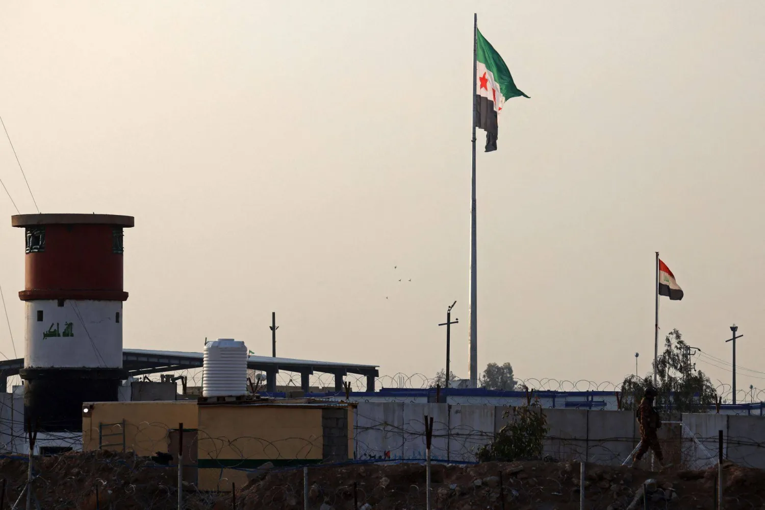  Syria's (L) and Iraq's national flags are pictured near the Iraqi-Syrian border, in Al-Qaim, western Iraq on January 23, 2026. (AFP) 