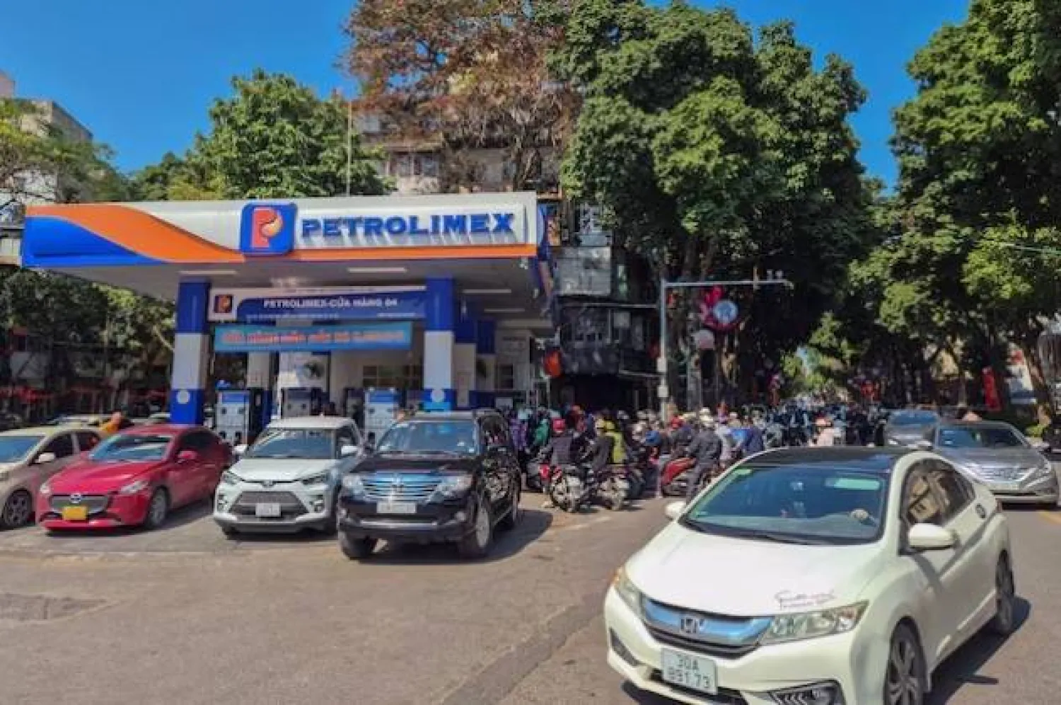 أشخاص يصطفون لشراء البنزين في محطة وقود في هانوي (رويترز)