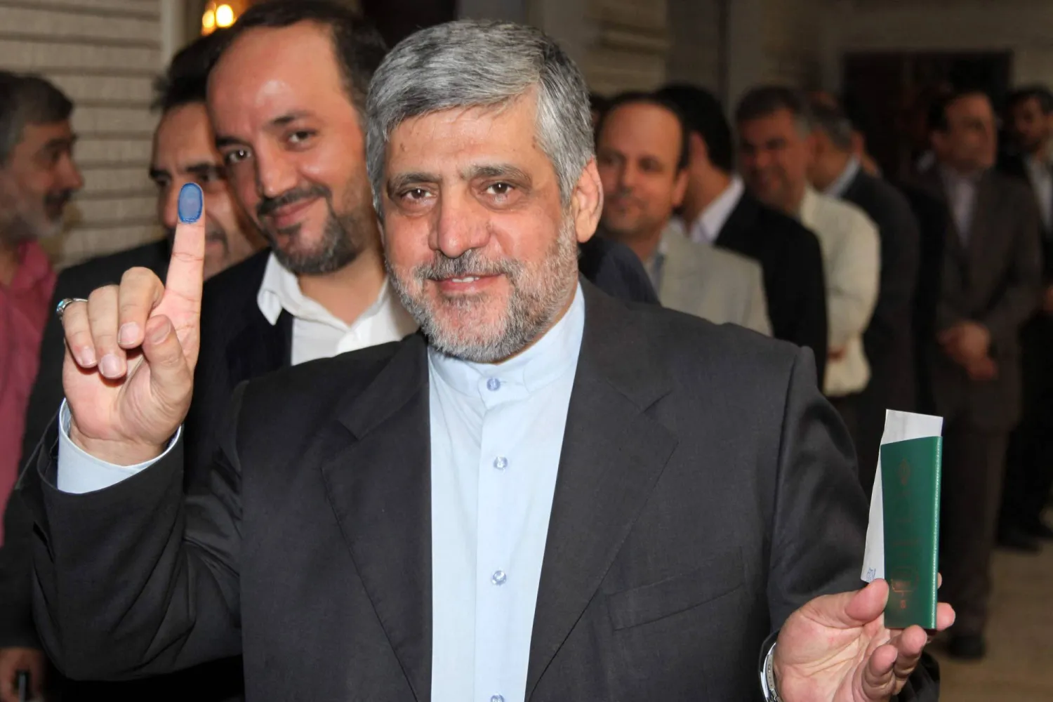 Iranian Ambassador to Syria Mohammad Reza Sheibani, shows his ink-stained finger as he votes in the first round of the Iranian presidential election on June 14, 2013 at the Iranian embassy in the Syrian capital, Damascus. (AFP)