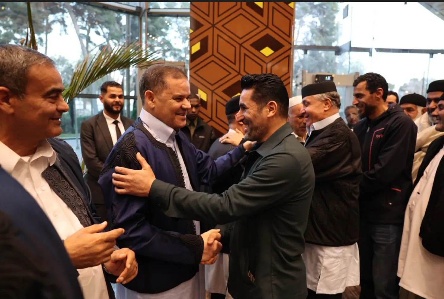 رئيس حكومة الوحدة عبد الحميد الدبيبة يصافح قائد ميليشيا «دعم الاستقرار» قبل مأدبة إفطار في الزاوية (مكتب الدبيبة)