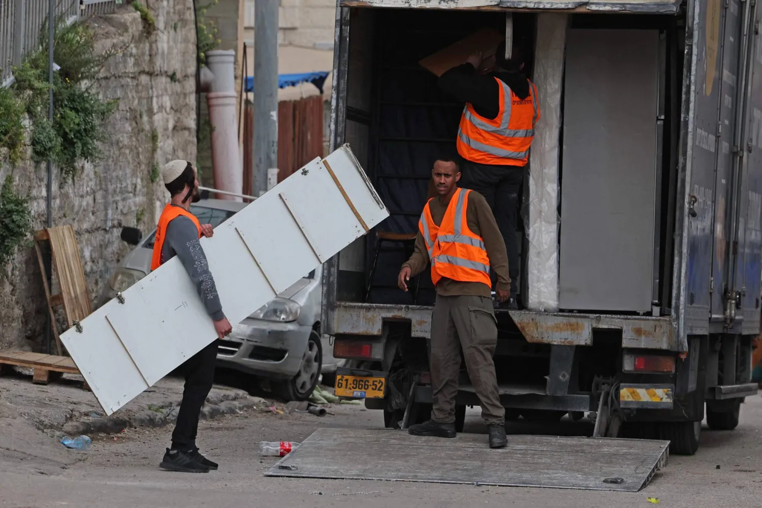 إسرائيليون يزيلون مقتنيات منزل فلسطيني خلال إخلاء 11 عائلة من منطقة بطن الهوى في حي سلوان بالقدس الشرقية (أ.ف.ب)