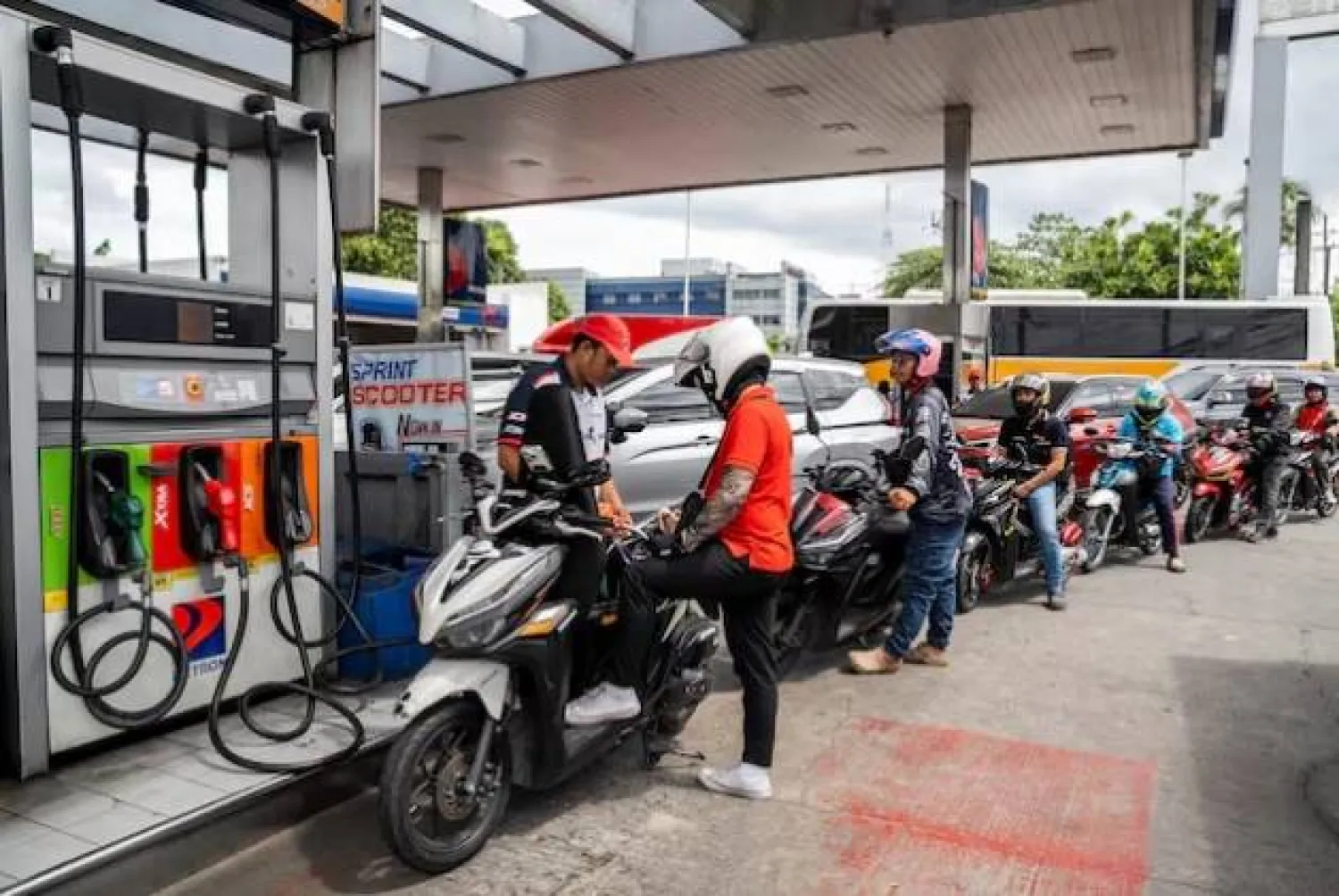 عامل يملأ دراجة نارية بالوقود في محطة بكويزون سيتي الفلبين (رويترز)