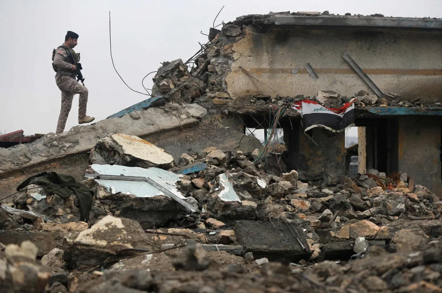 Irak'ın batısındaki bir askeri kliniğe düzenlenen hava saldırısının yol açtığı yıkımın bir bölümü (AFP)