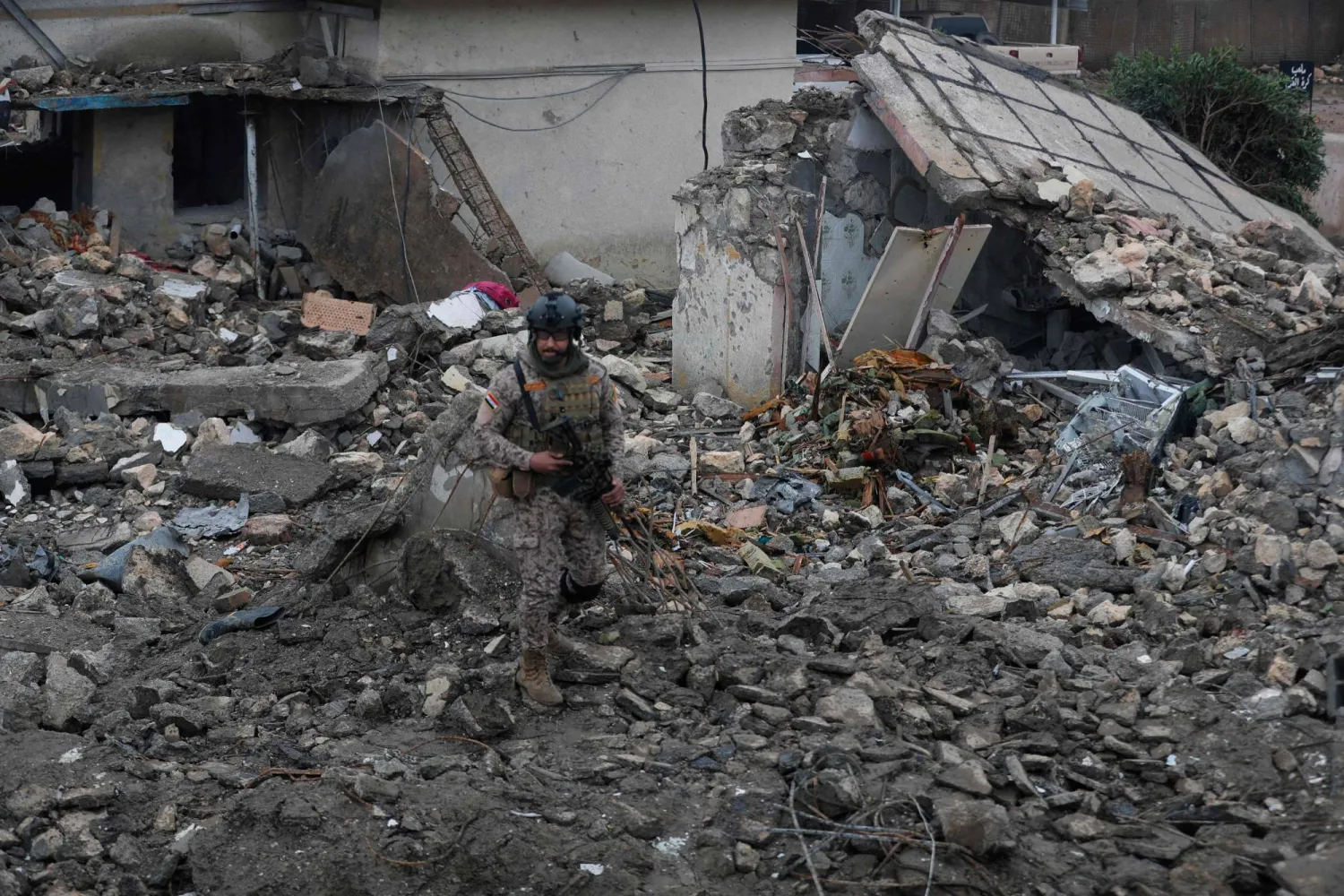 An Iraqi soldier stands guard at the site of a destroyed healthcare center in the Habbaniyah military base, which was targeted by in an airstrike killing seven security personnel and wounding 13 others, in Habbaniyah, west of Baghdad on March 26, 2026. (AFP)