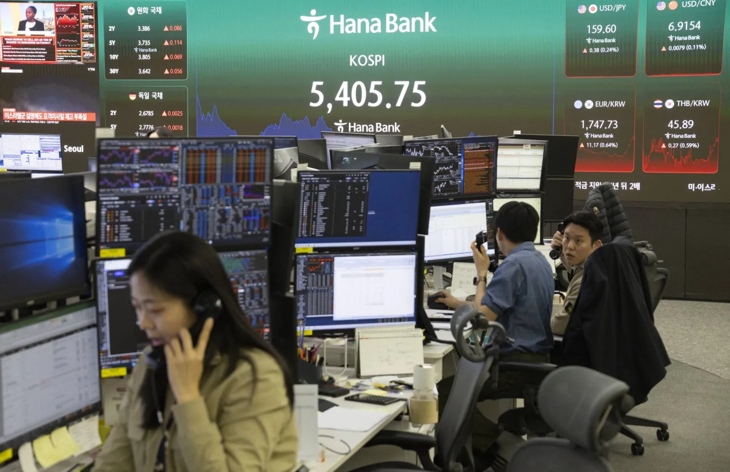 متداولون يعملون أمام شاشات تعرض مؤشرات الأسهم في بنك «هانا» بسيول (إ.ب.أ)