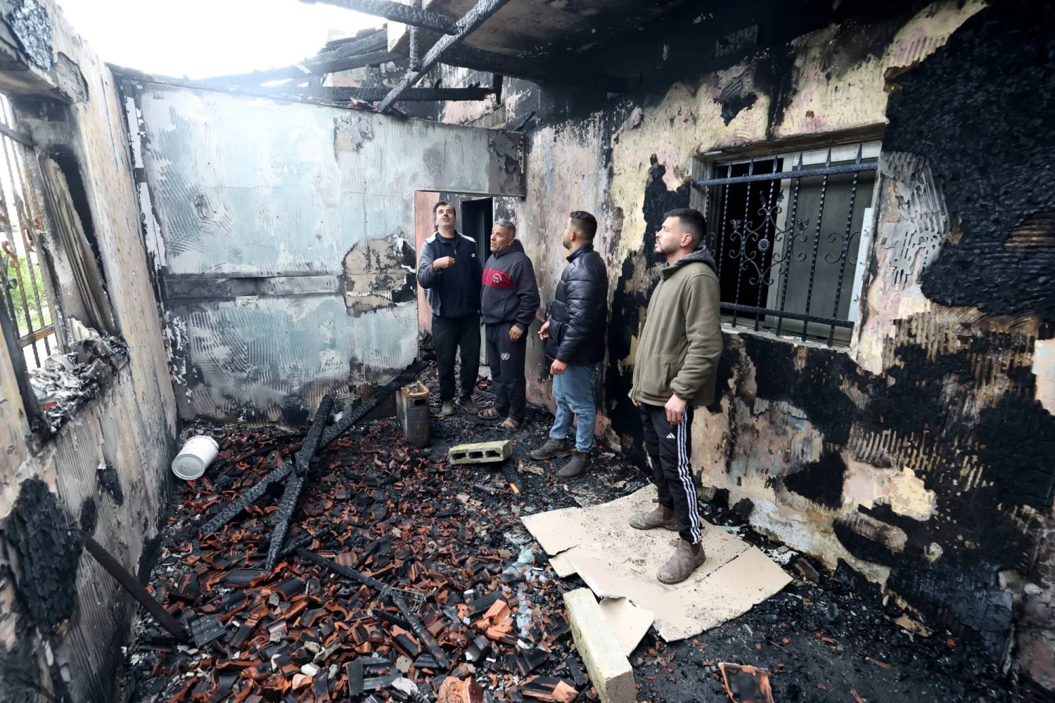 فلسطينيون يتفقدون منزلاً متضرراً في قرية الفندقومية بالضفة الغربية جنوب جنين بعد هجوم المستوطنين الإسرائيليين 22 مارس 2026 (إ.ب.أ)