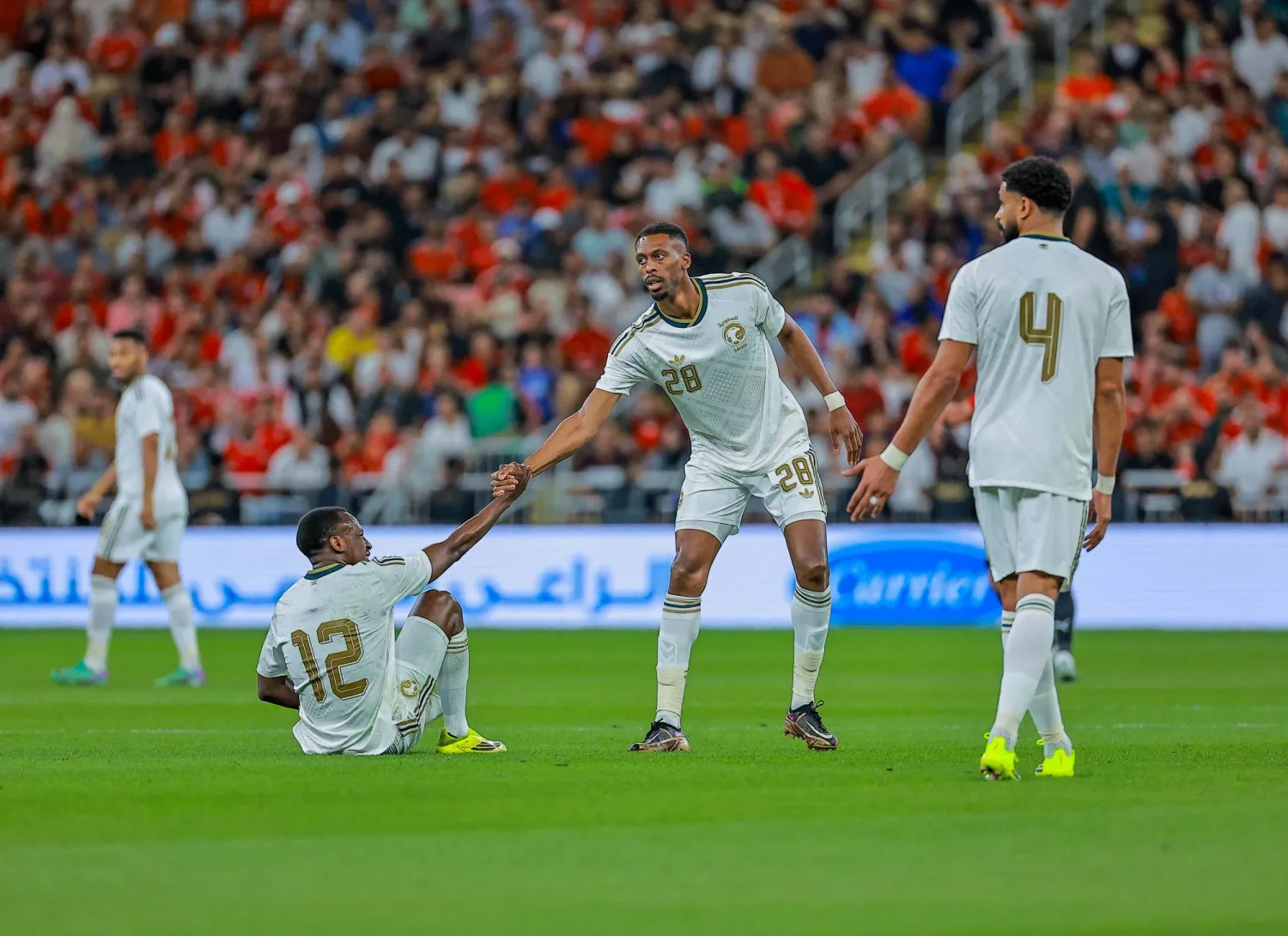 سعود عبد الحميد يتلقى مساعدة من زميله محمد كنو لحظة سقوطه على أرض الملعب خلال المباراة (تصوير: محمد المانع) 