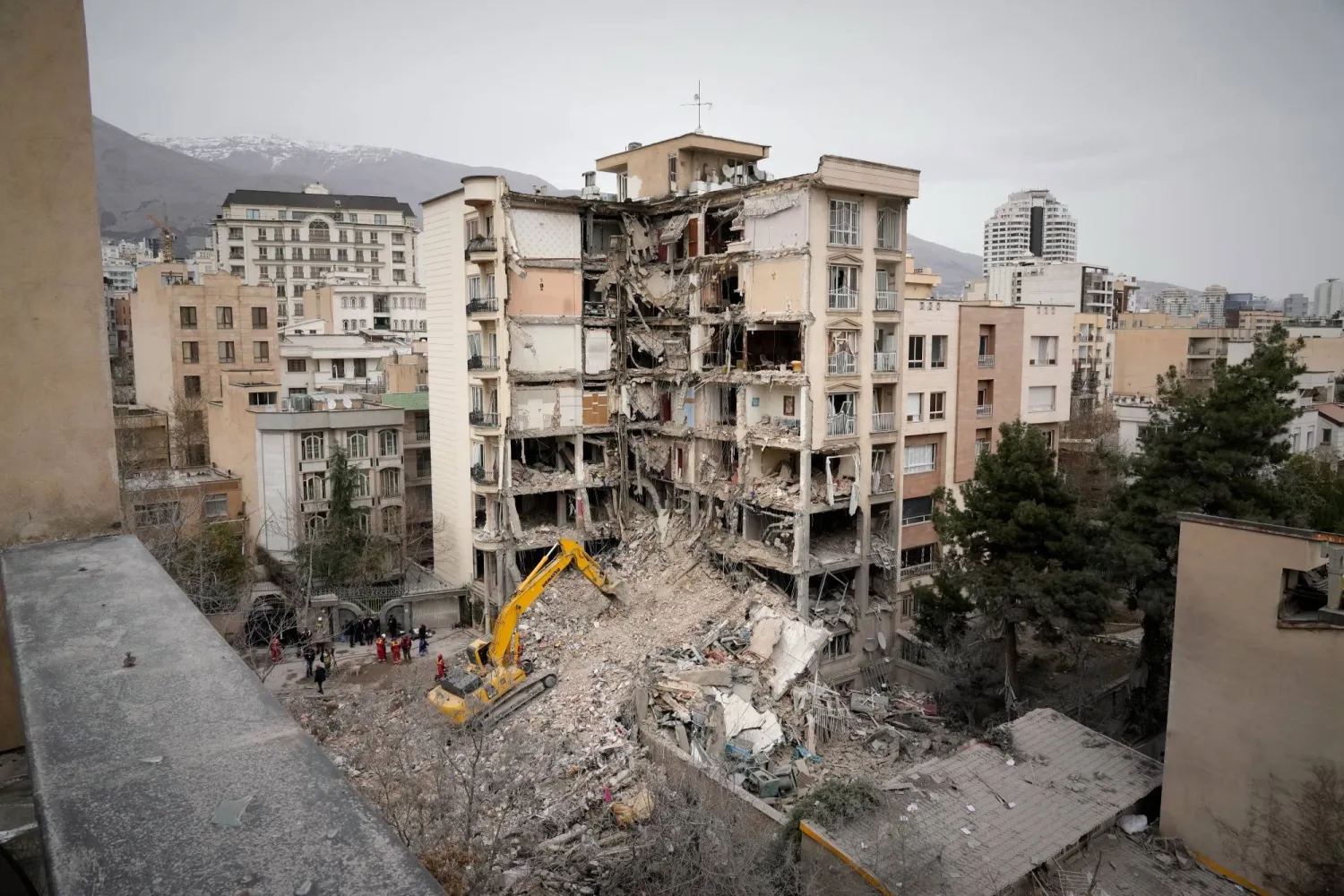 Iranian Red Crescent emergency workers use a bulldozer to clear rubble from a residential building that was hit in an earlier U.S.-Israeli strike in Tehran, Iran, Monday, March 23, 2026. (AP Photo/Vahid Salemi)