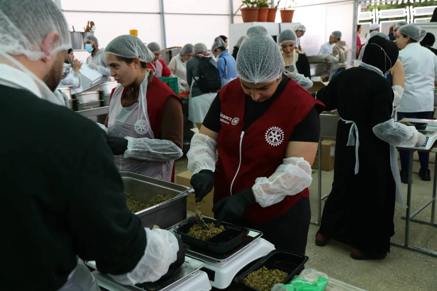 متطوعون في مطبخ خيري في بيروت يحضِّرون وجبات جاهزة للعائلات النازحة من الحرب (أ.ف.ب)