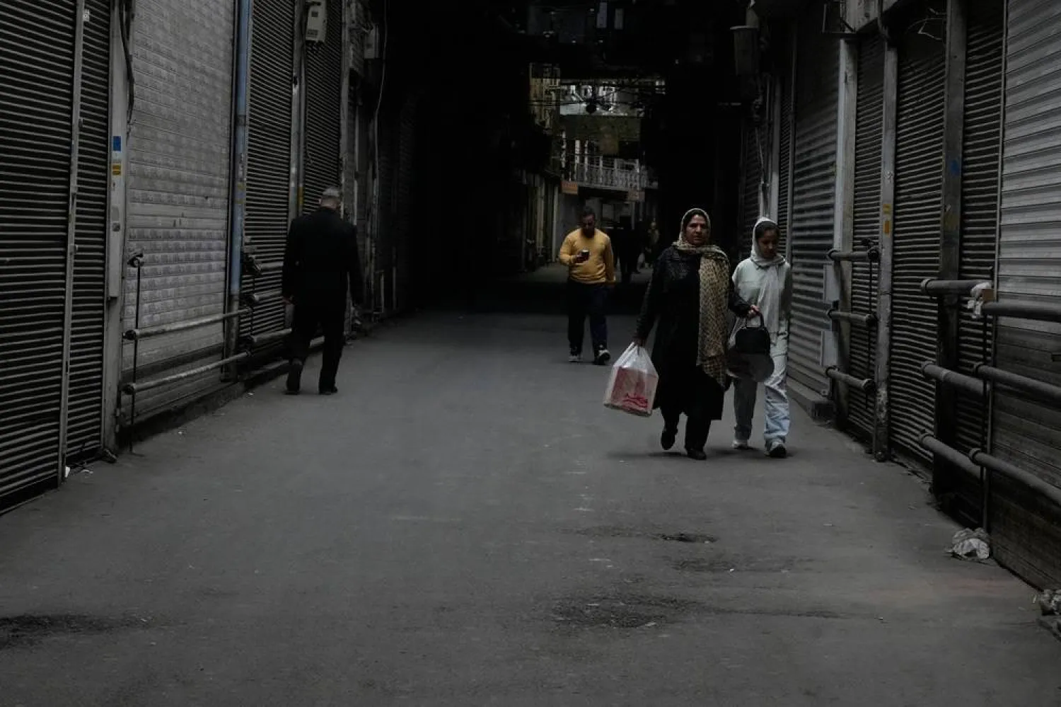  People walk past closed shops at the nearly empty traditional main bazaar during Iranian New Year, or Nowruz, holidays in Tehran, Iran, Sunday, March 29, 2026. (AP) 