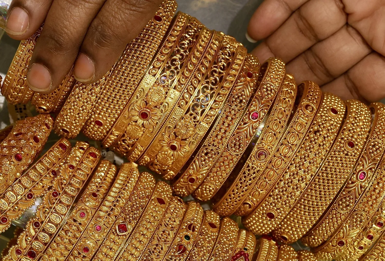An Indian woman displays a gold jewelry piece at a jewelry store in Bangalore (AFP)