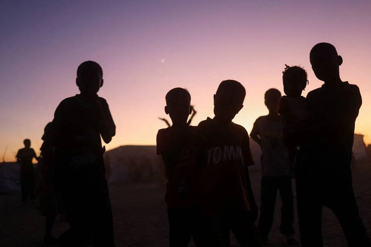 Sudanese refugee children from el-Fashir stand at sunset in the Tine transit camp amid the conflict between the paramilitary Rapid Support Forces (RSF) and the Sudanese Army, in eastern Chad, November 23, 2025. (Reuters)