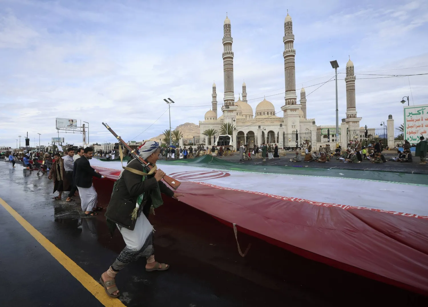 عناصر حوثية ترفع العلم الإيراني في صنعاء (إ.ب.أ)