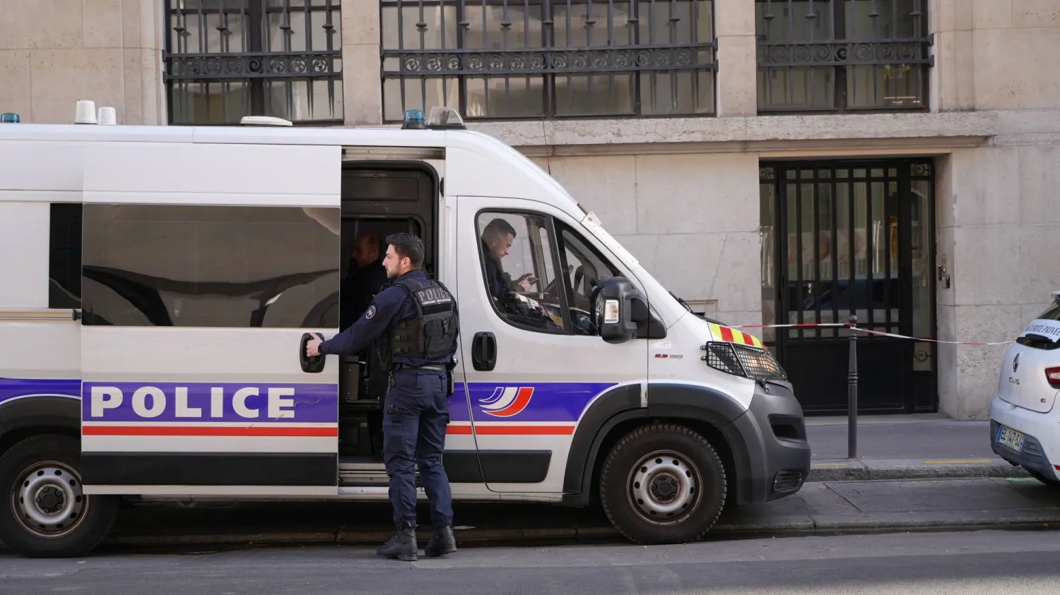 Police stand outside the Bank of America building in Paris, Saturday, March 28, 2026. (AP Photo/Nicolas Garriga)