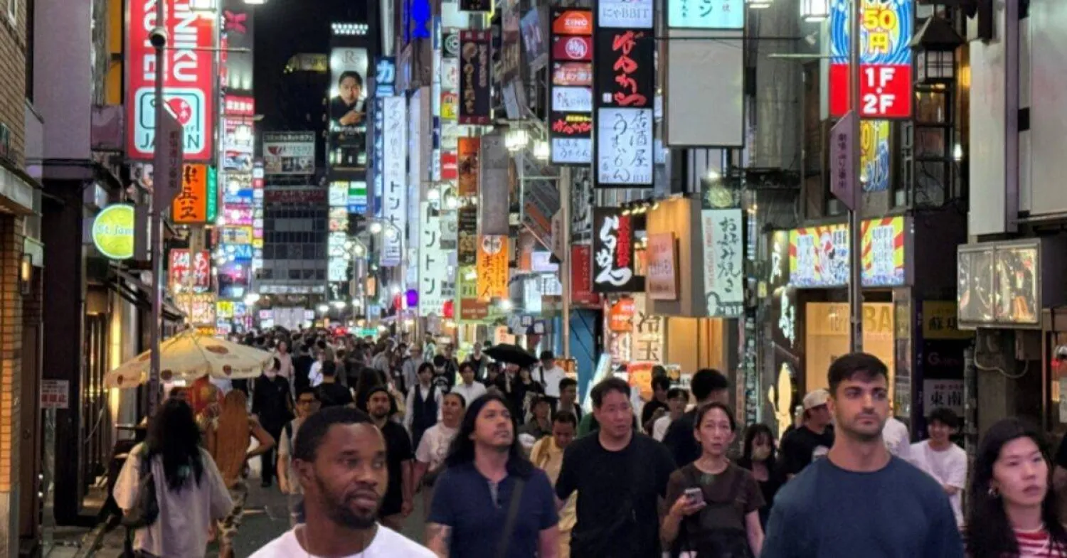 أشخاص يتجولون بمنطقة تسوق في طوكيو (رويترز)