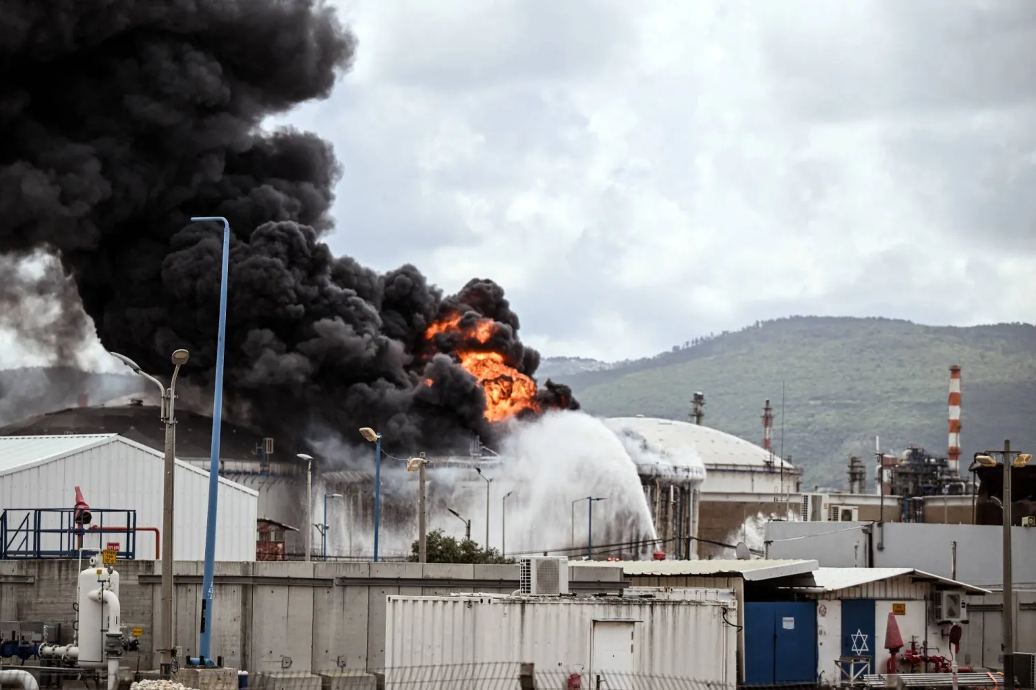 جانب من الحريق بمبنى صناعي وناقلة وقود في مصافي نفط بحيفا (رويترز)