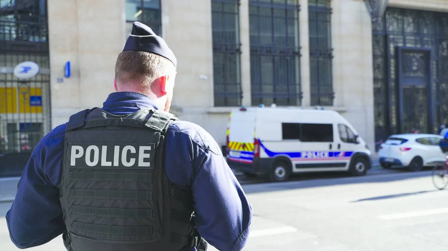 Police stand outside the Bank of America building in Paris, Saturday, March 28, 2026. (AP Photo/Nicolas Garriga)