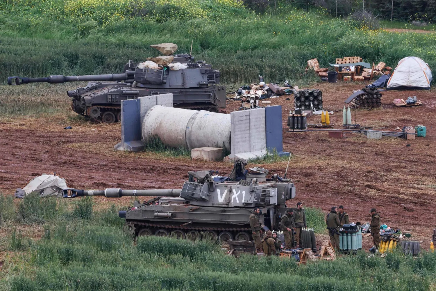 Israeli army soldiers stand next to a self-propelled Howitzer artillery gun positioned in the upper Galilee in northern Israel near the border with southern Lebanon on March 29, 2026. (Photo by Jalaa MAREY / AFP) / 