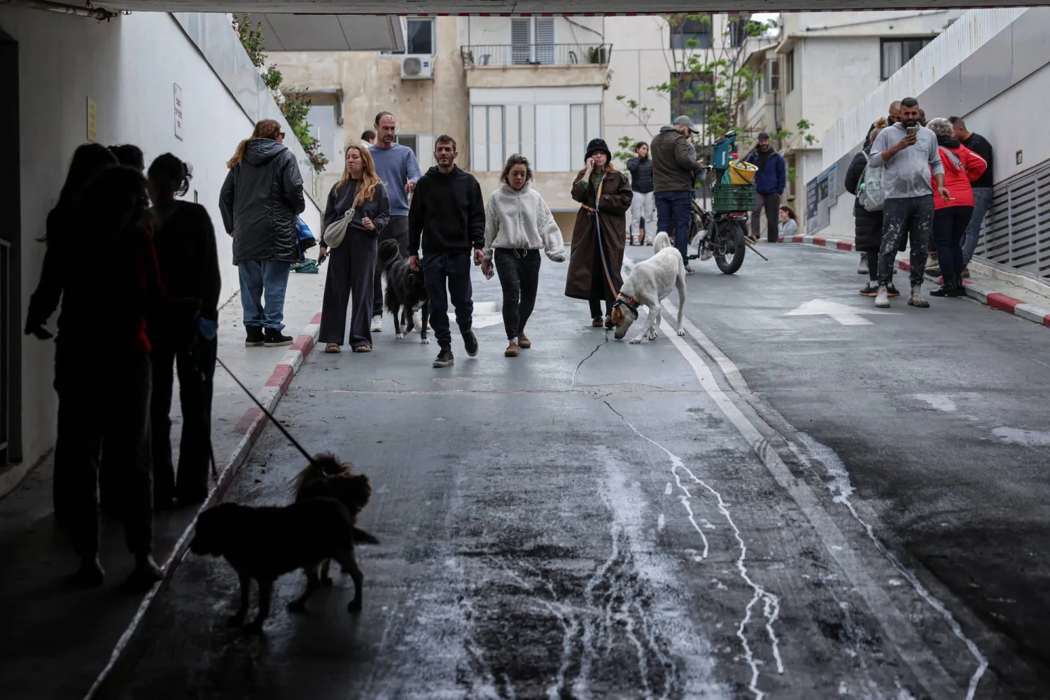 إسرائيليون يتوجهون نحو موقف سيارات تحت الأرض للاحتماء مع دوي صفارات الإنذار في تل أبيب (رويترز)