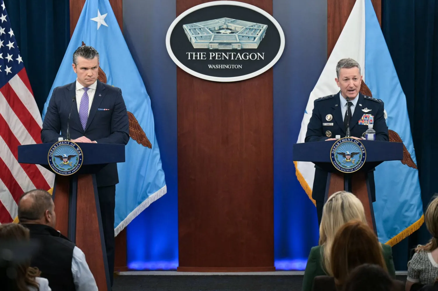 وزير الدفاع الأميركي بيت هيغسيث يستمع إلى رئيس هيئة الأركان المشتركة الجنرال دان كين خلال مؤتمر صحافي مشترك في البنتاغون (أ.ف.ب)