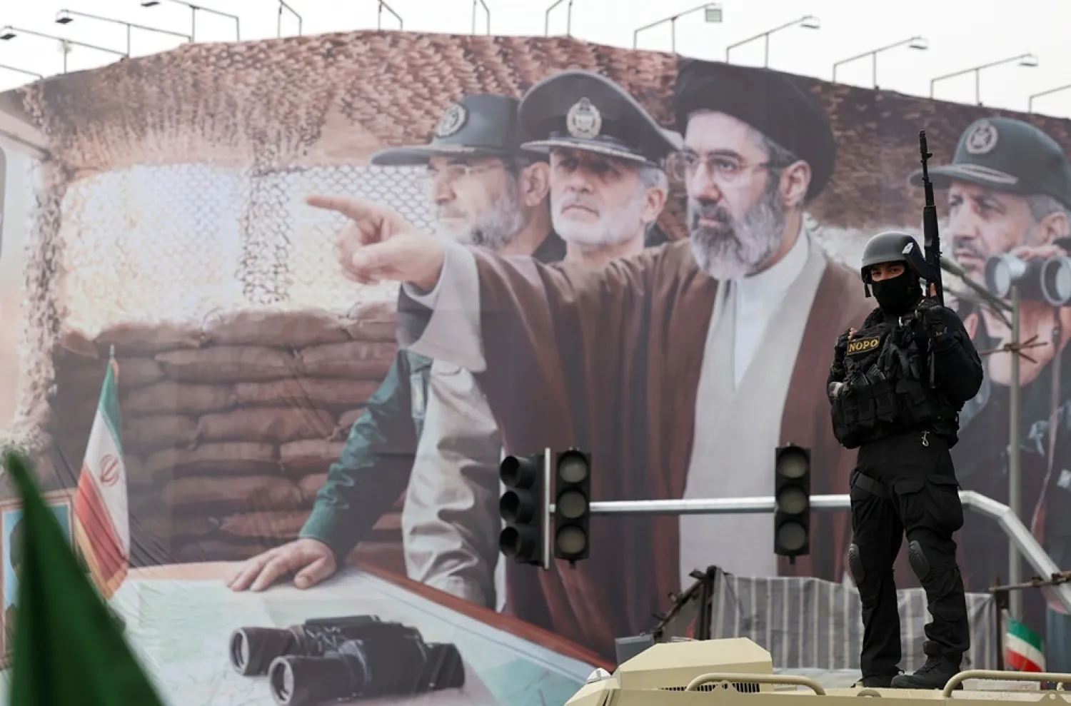 A member of the Iranian security forces stands guard in front of a billboard showing Iranian Supreme Leader Mojtaba Khamenei and Iranian military commanders during a rally to mark International Quds Day in Tehran, Iran, 13 March 2026. (EPA)