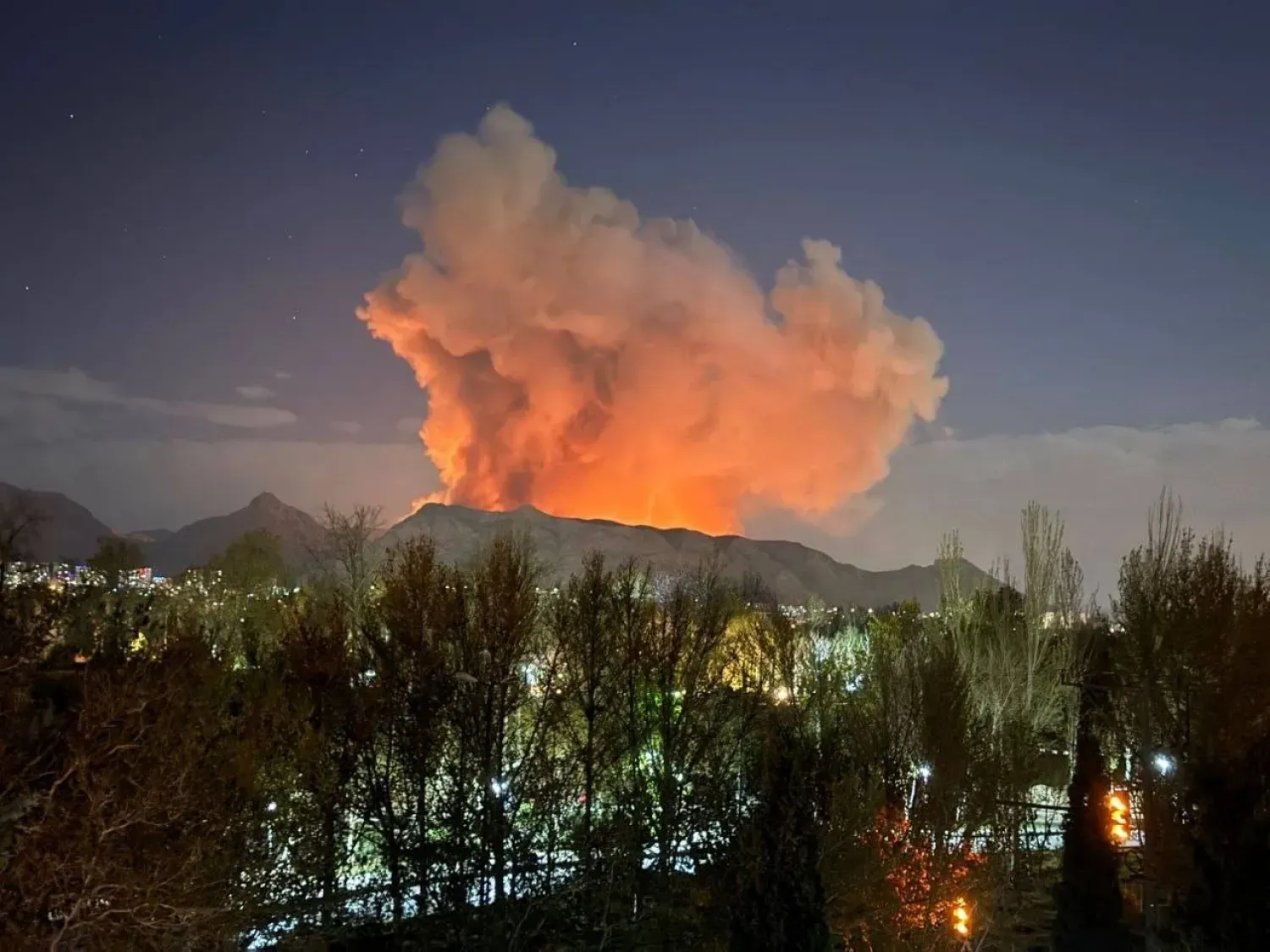 Dün sabaha karşı İran'ın orta kesimlerindeki İsfahan şehrinde bir mühimmat deposundan yükselen duman ve alevler (sosyal medya)