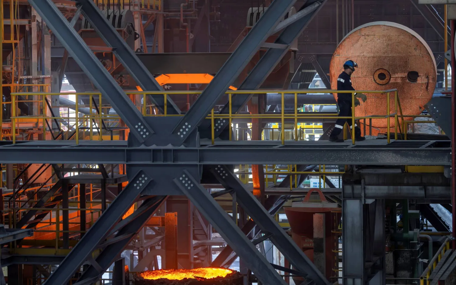 يمشي عامل فولاذ عبر فرن القوس الكهربائي في مصنع هاسليك ميلت قرب مدينة بيلجيك (رويترز)