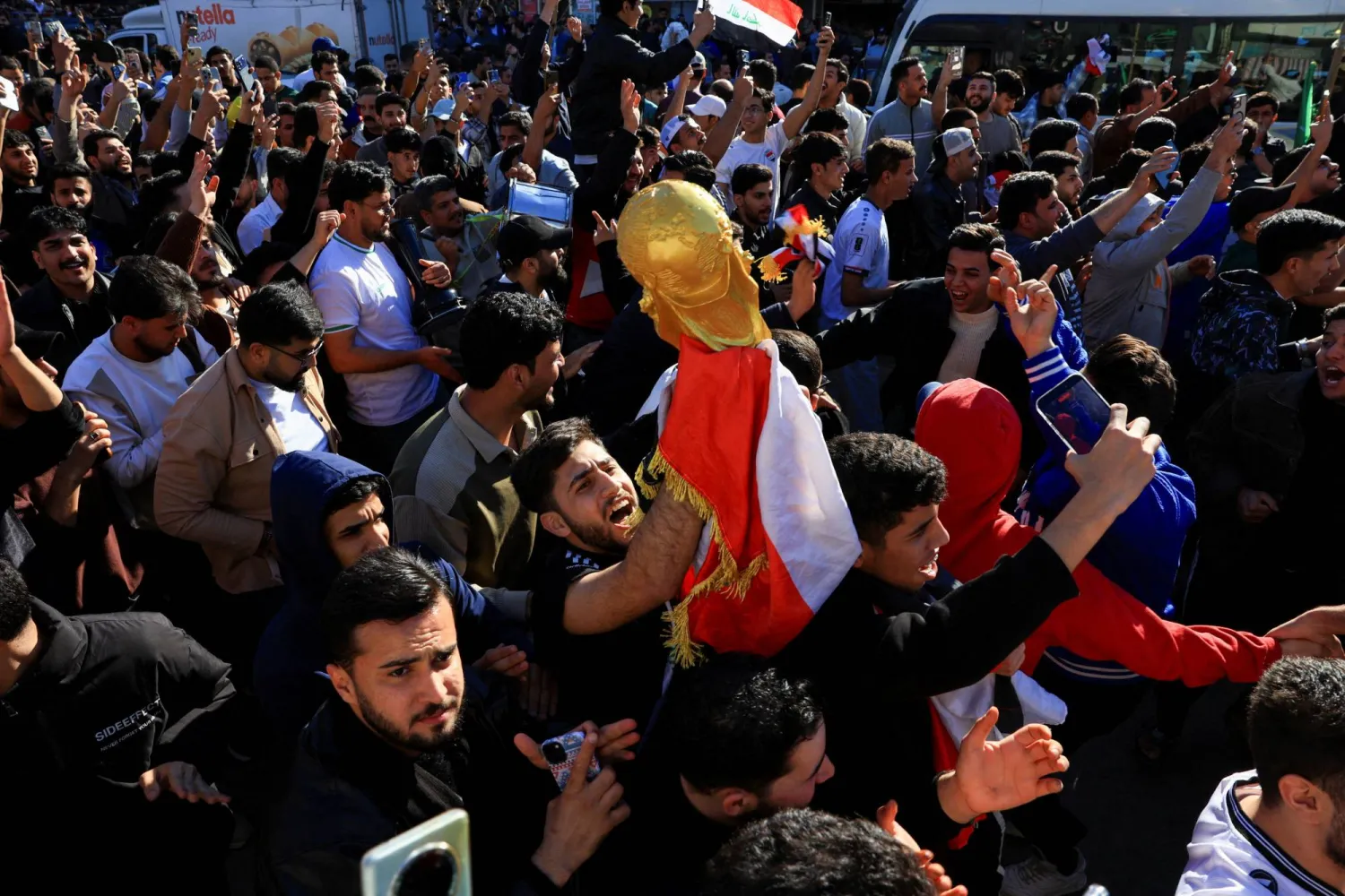 المحتفلون يرفعون تمثال كأس العالم (رويترز)