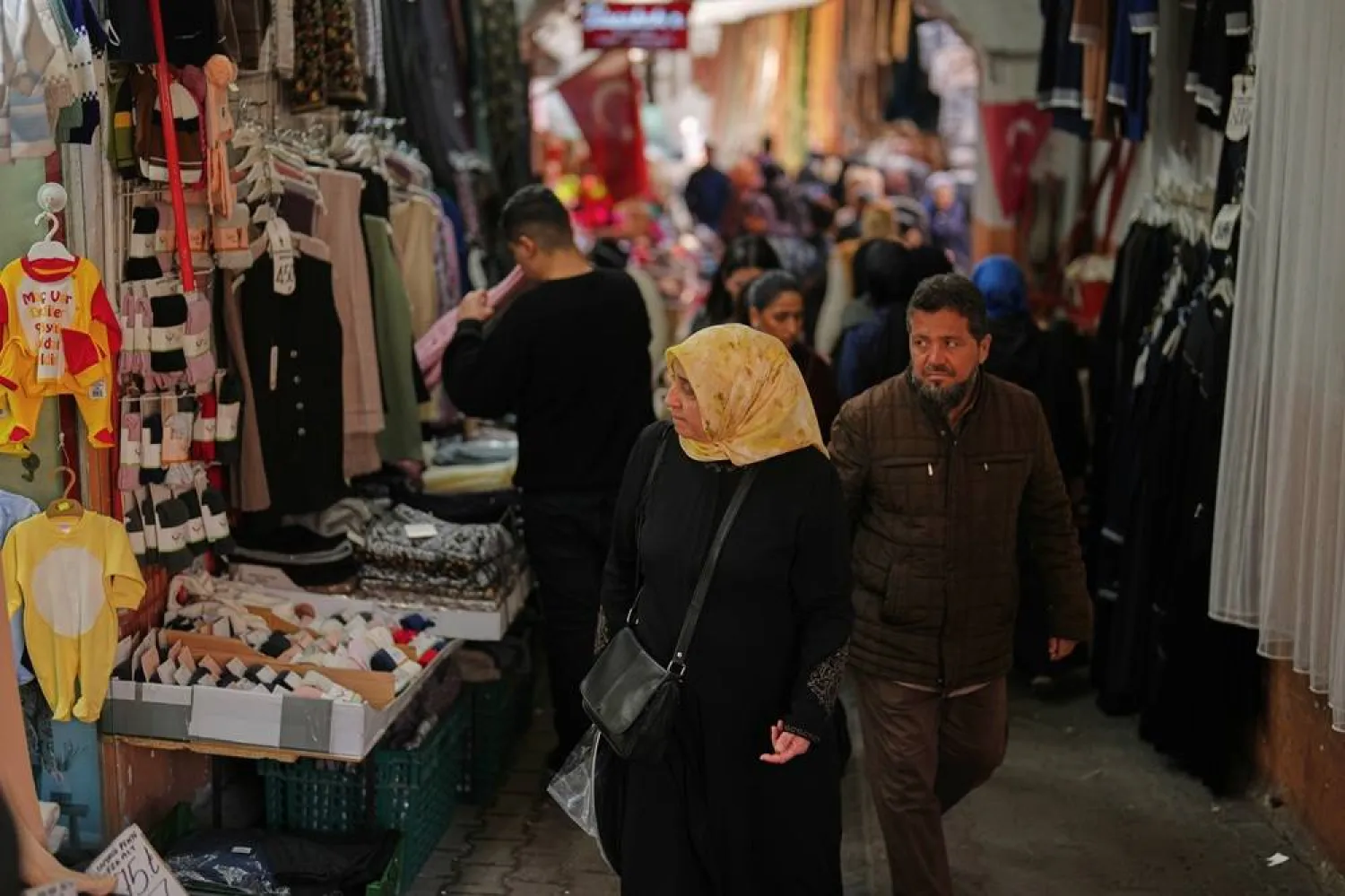  People walk past displayed items in a clothes shop at Eminonu commercial area, in Istanbul, Türkiye, Thursday, March 26, 2026. (AP)