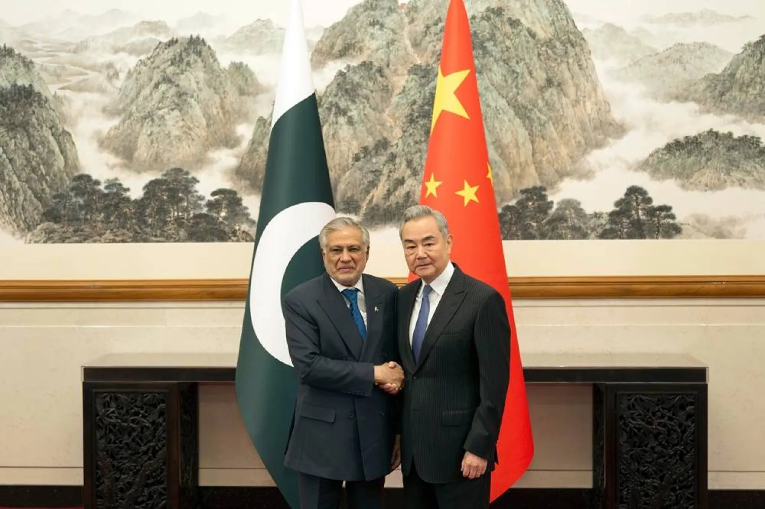 In this photo released by Xinhua News Agency, Chinese Foreign Minister Wang Yi, right, poses for photos with Pakistani Deputy Prime Minister and Foreign Minister Mohammad Ishaq Dar in Beijing on Tuesday, March 31, 2026. (Xinhua via AP) 