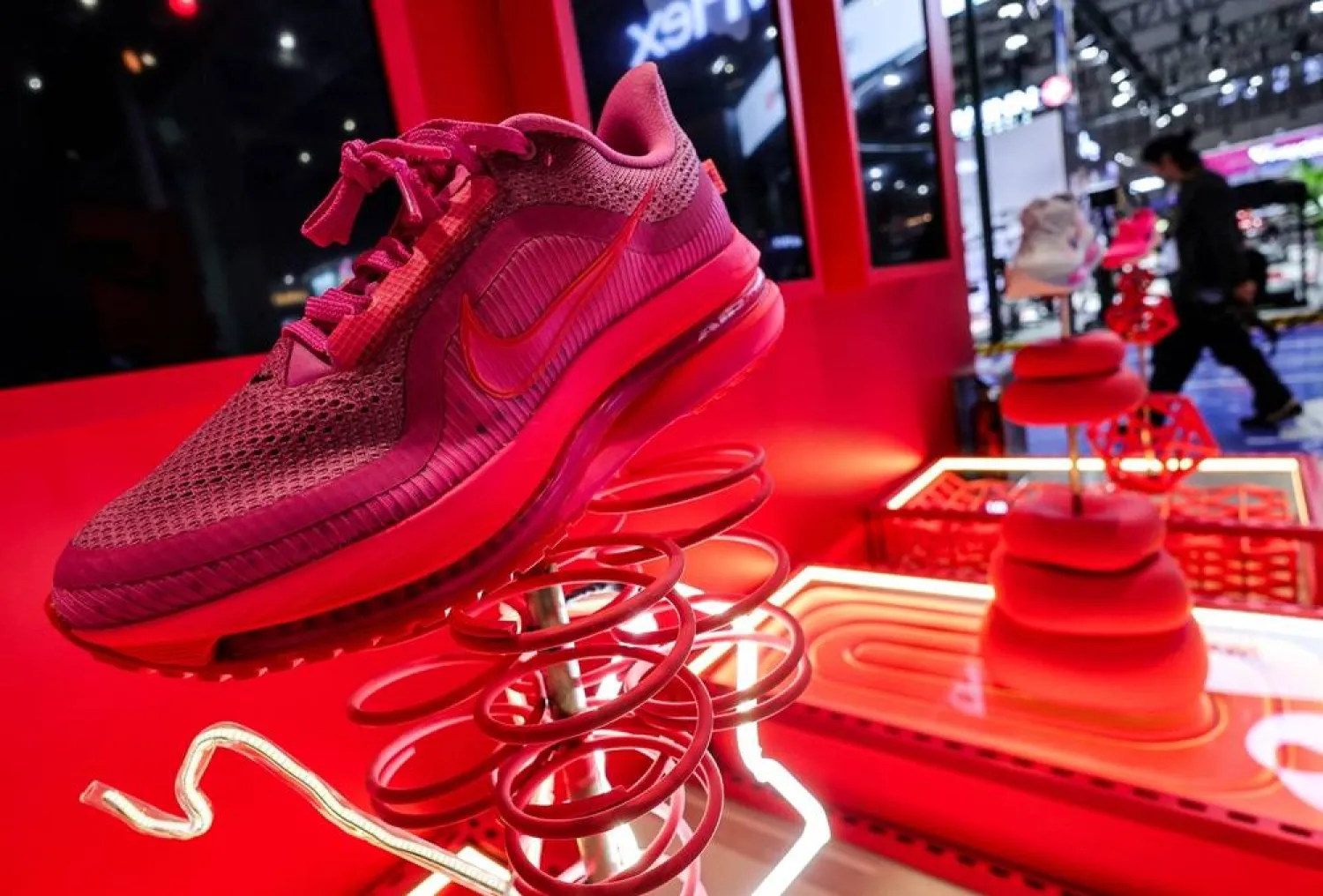A man walks past Nike booth with installation of shoes at the 8th China International Import Expo (CIIE) venue in Shanghai, China, November 5, 2025. (Reuters) 