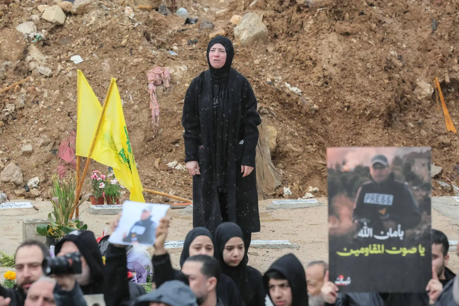 سيدة تشارك في تشييع صحافيين قتلوا بغارة إسرائيلية بجنوب لبنان (أ.ف.ب)
