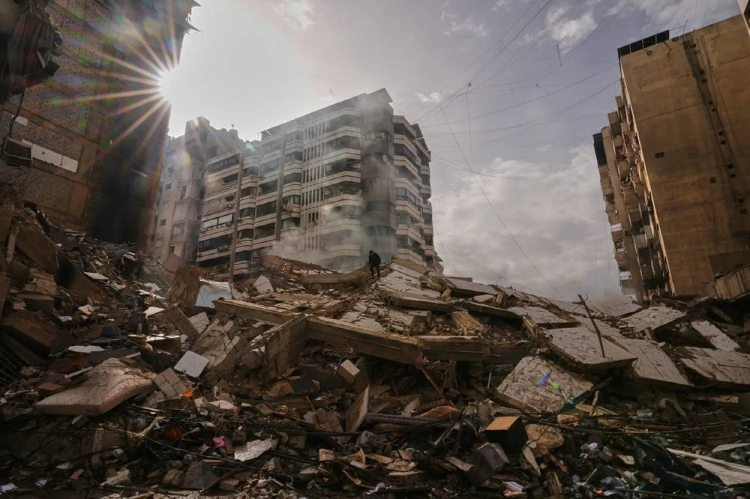 A man stands atop the rubble as smoke rises from a building destroyed in an Israeli airstrike in Dahieh, Beirut's southern suburbs, Lebanon, March 14, 2026. (AP)