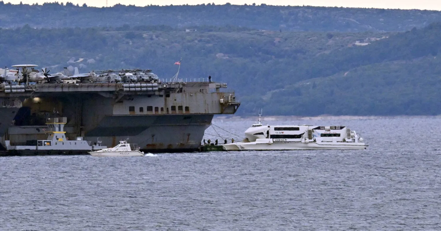 Harbor tugboats and other civilian vessels approach the US Navy aircraft carrier USS Gerald R. Ford at an anchor point off the Croatian coastal city of Split on March 28, 2026, for a scheduled port visit and maintenance stop following involvement Middle East war operations. (AFP)