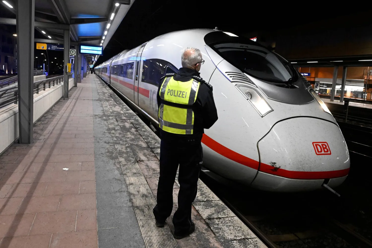 A police officer stands on a platform at Siegburg station where a Deutsche Bahn ICE train is parked, in Siegburg, Germany, early Friday, April 3, 2026, after a man was arrested on Thursday after threatening an attack on a high-speed train. (Roberto Pfeil/dpa via AP)