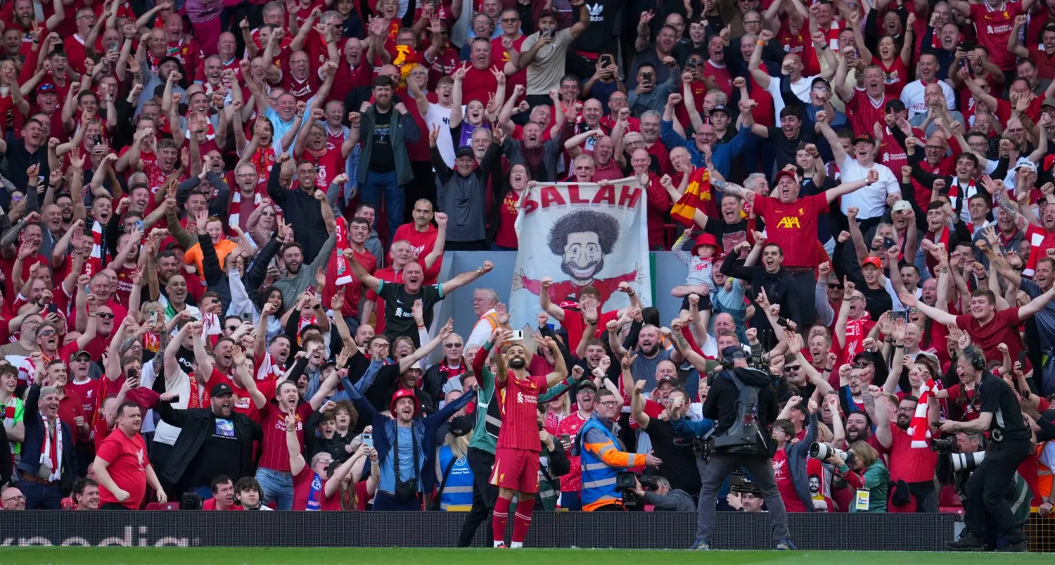 Liverpool's Mohamed Salah takes a selfie with a fans smartphone as he celebrates after scoring his side's fourth goal during the English Premier League soccer match between Liverpool and Tottenham Hotspur at Anfield in Liverpool, England, Sunday, April 27, 2025. (AP)