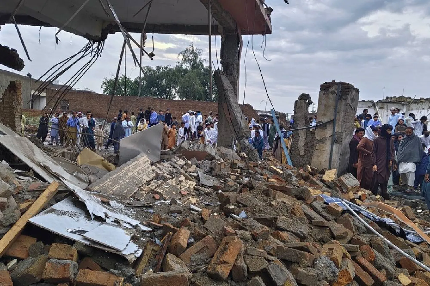  Local residents look at a damaged area of a police station after an overnight deadly bombing in the Bannu district of northwestern Pakistan, Friday, April 3, 2026. (AP) 