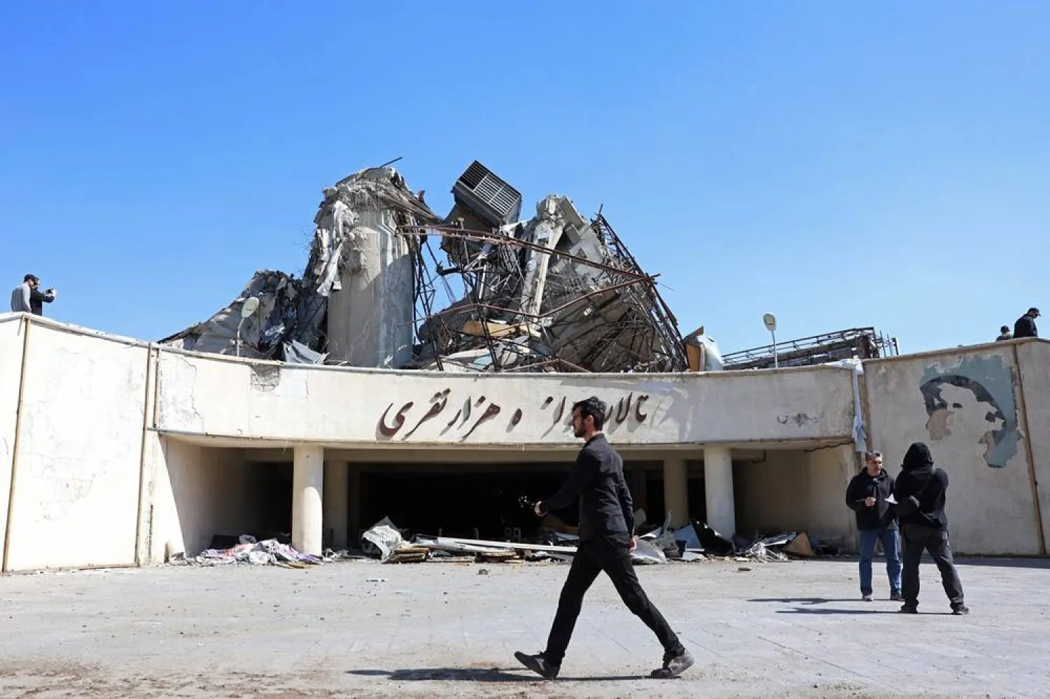A media representative walks past a heavily damaged building following a strike at the Azadi Sport Complex in Tehran on April 3, 2026. (AFP)