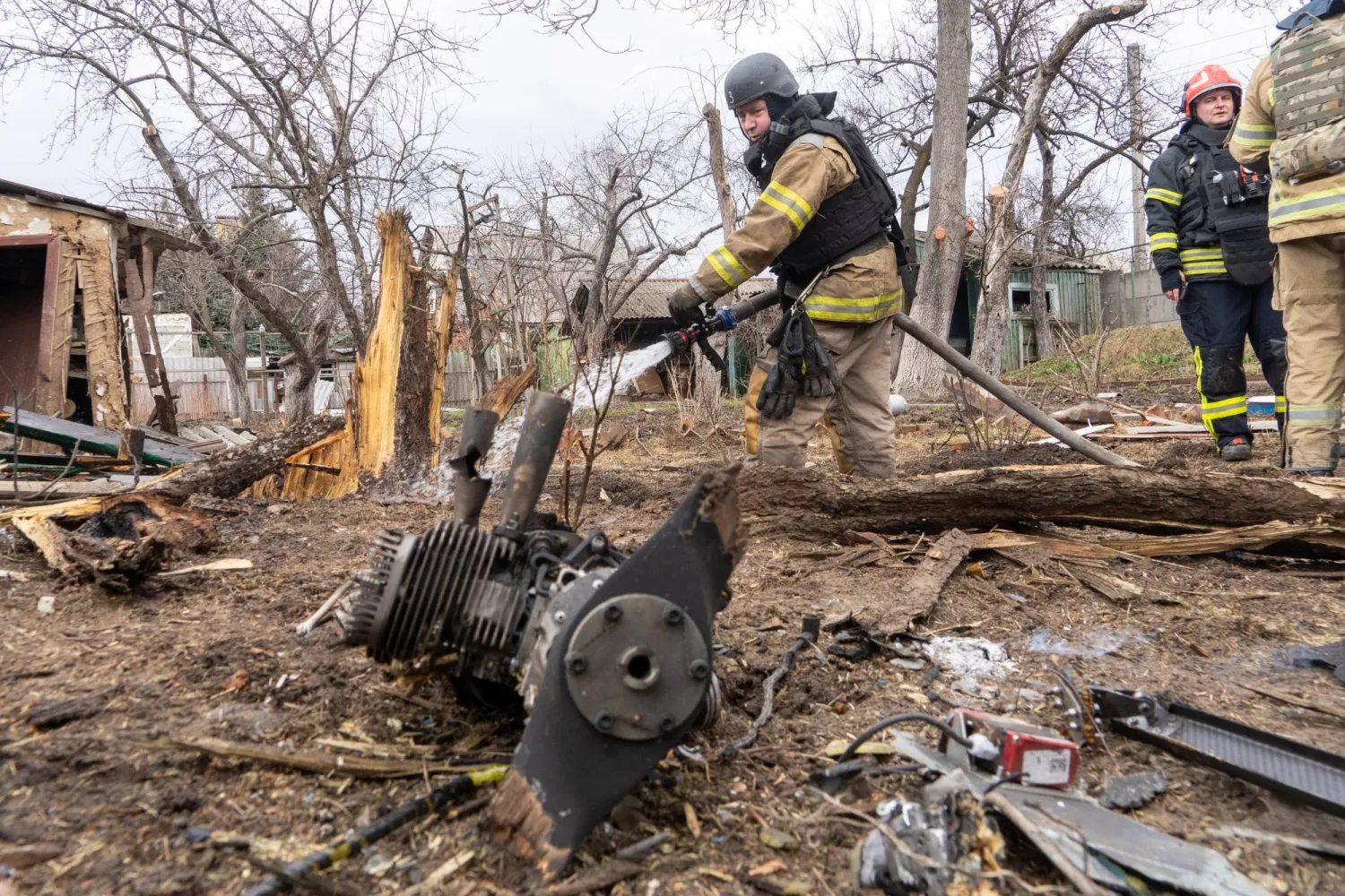 Rescue workers try to put out a fire caused by the fragments of a Russian drone that hit a private house during air attack in Kharkiv, Ukraine, Wednesday, March 25, 2026. (AP Photo/Andrii Marienko)